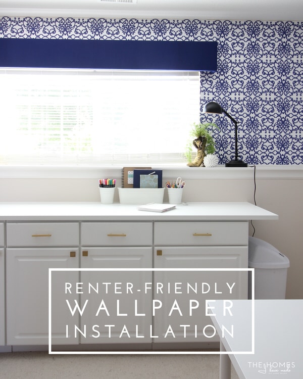 A home office with renter-friendly wallpaper installed above a cabinet workspace and text overlay