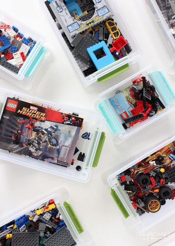 Overhead view of opened clear bins of various sizes containing a variety of Lego pieces