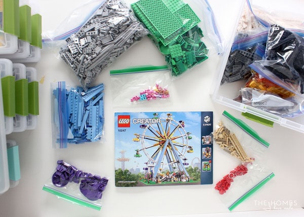Overhead view of Ziplock bags containing Lego pieces organized by color surrounding a Lego instructional manual 