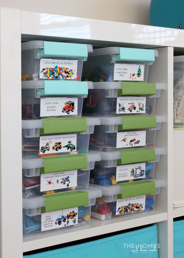 Photo of clear labeled bins containing Lego pieces stacked vertically inside a shelf 