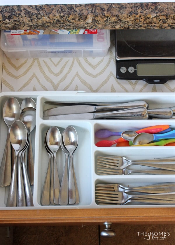 Sort the silverware drawer in the kitchen with an organizer