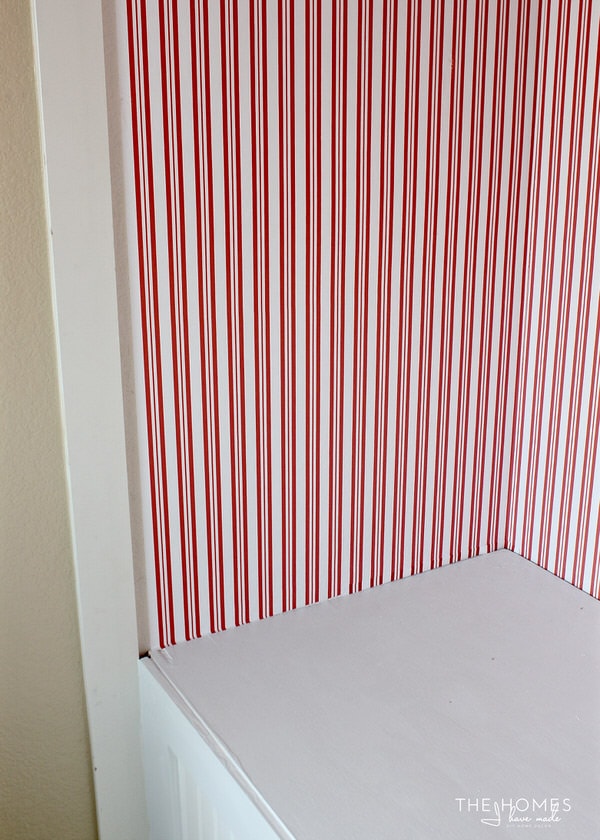 red and white striped wallpaper hung in a closet.
