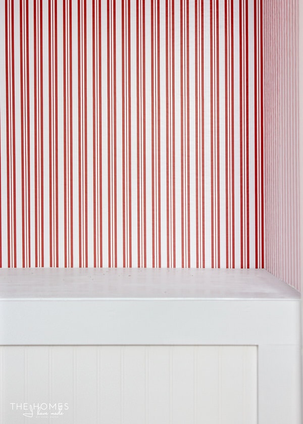 red and white striped wall paper on textured walls in a closet