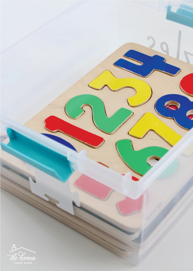 Vertical image of a wooden kid puzzle inside an open clear container
