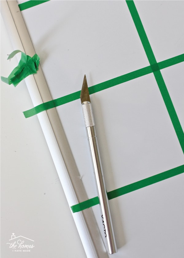 An X-acto knife cuts along the frame edge of a whiteboard
