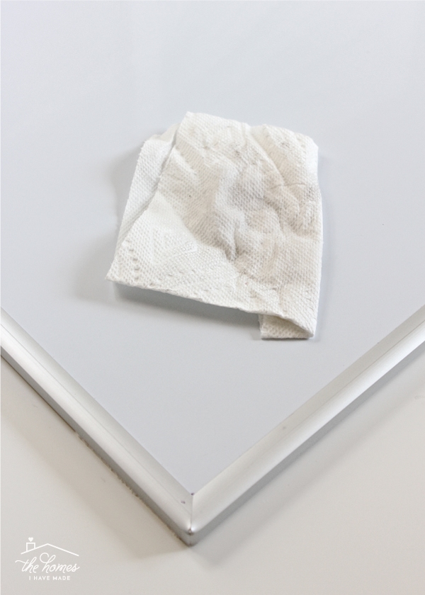 A paper towel cleans a dirty dry erase board