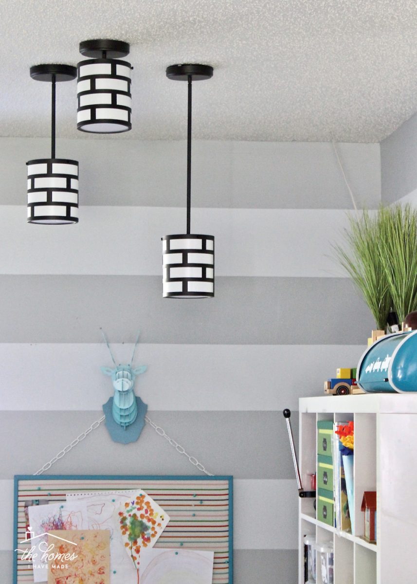 Black and white plug-in pendants against a grey striped wall