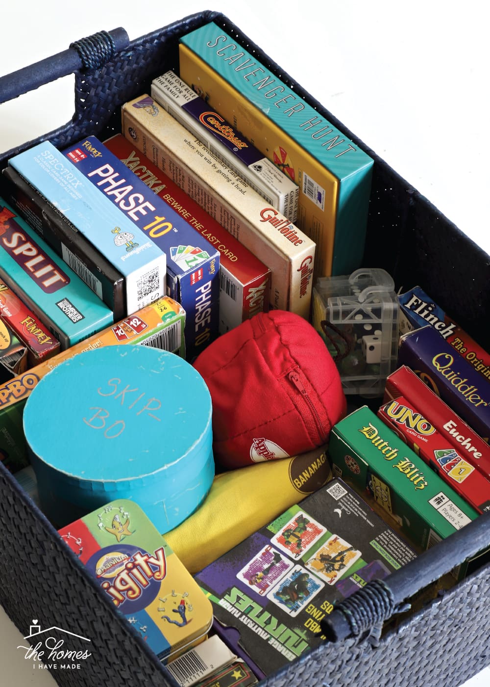 Vertical image of whicker basket containing a variety of card games 