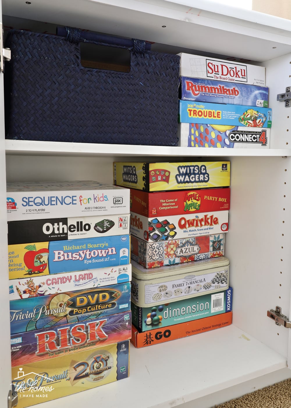 Vertical image of board games stacked inside a cabinet