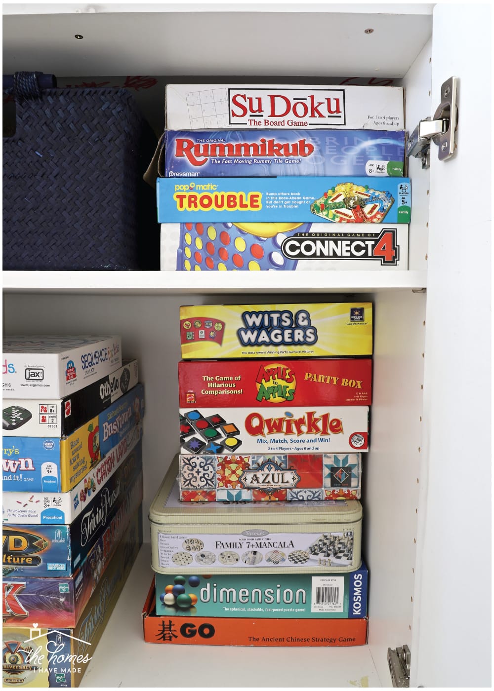 Vertical image of board games stacked vertically inside a cabinet