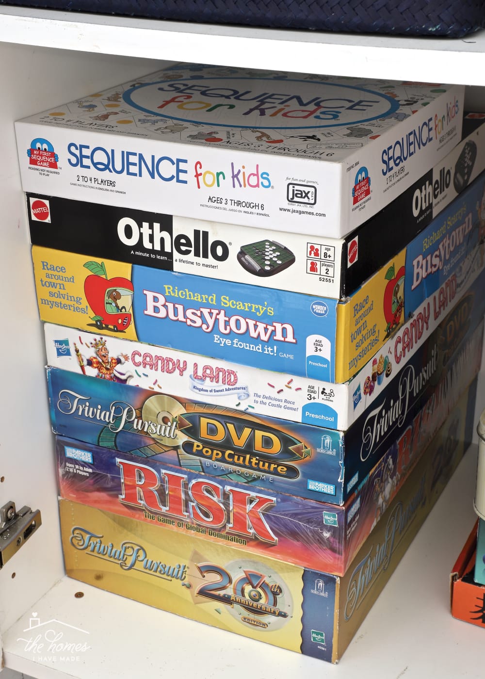 Vertical image of board games stacked vertically inside a cabinet