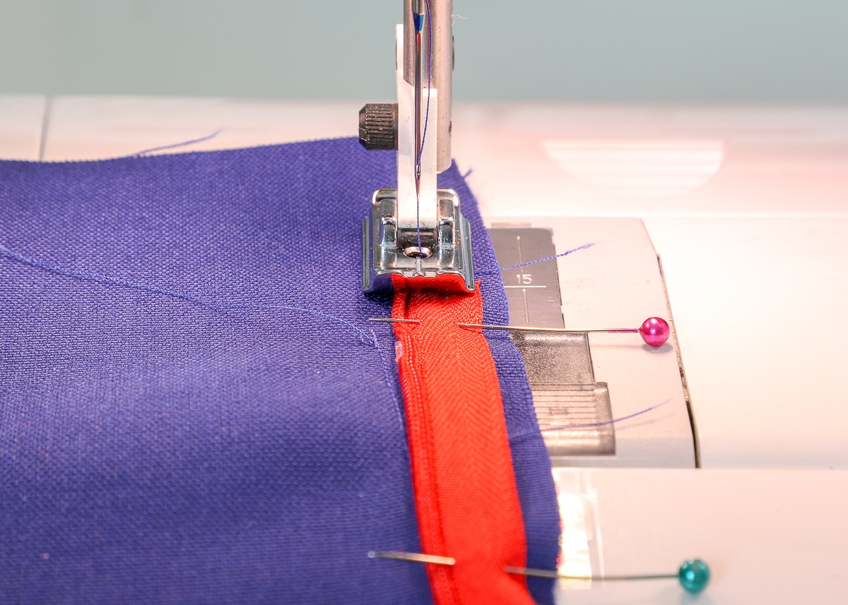 the fabric and invisible zipper are fed through the sewing machine