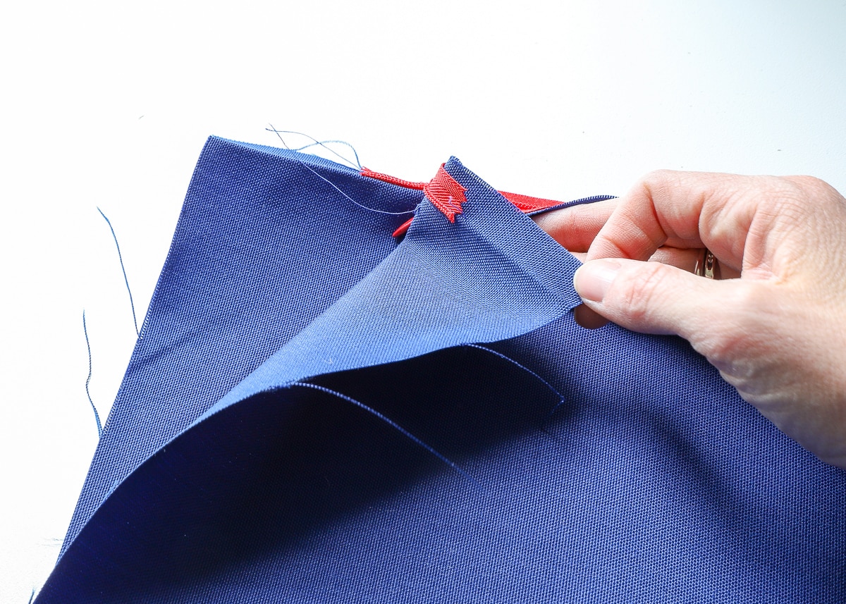 two pieces of blue fabric stacked and a red zipper between them