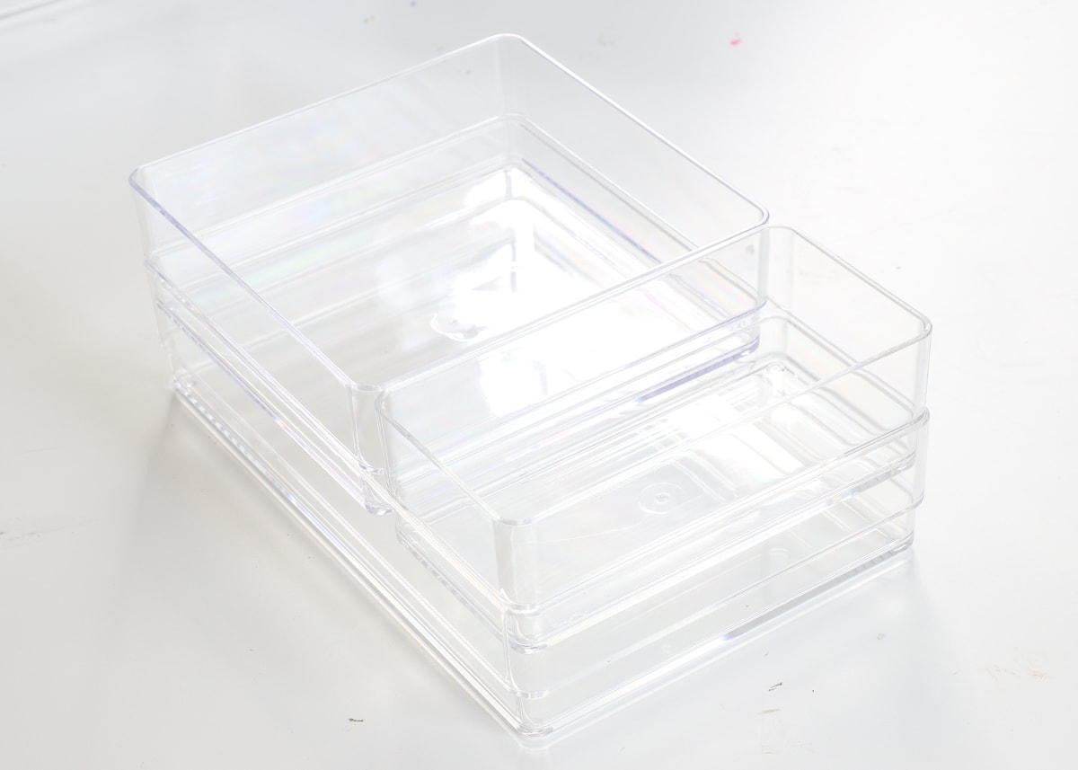 Clear acrylic drawer organizers of varying sizes stacked