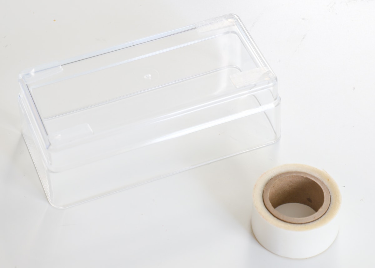 Double-sided tape on the bottom four corners of a clear acrylic drawer organizer