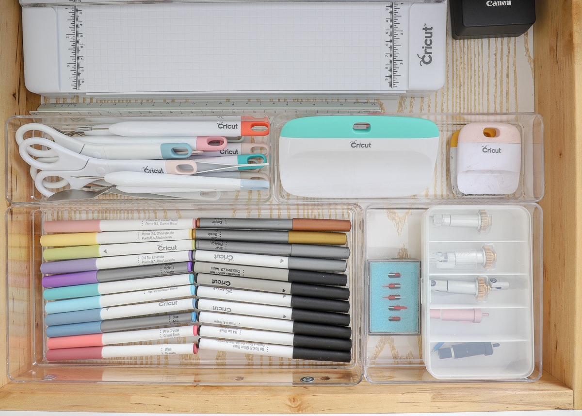 A drawer full of office items organized with drawer organizers