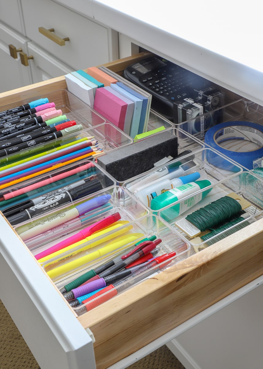 A drawer full of office items organized with drawer organizers