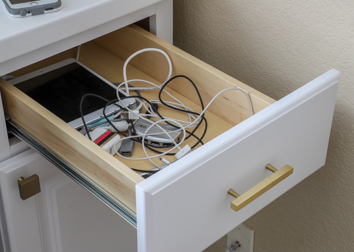 A disorganized office drawer full of electronic cords
