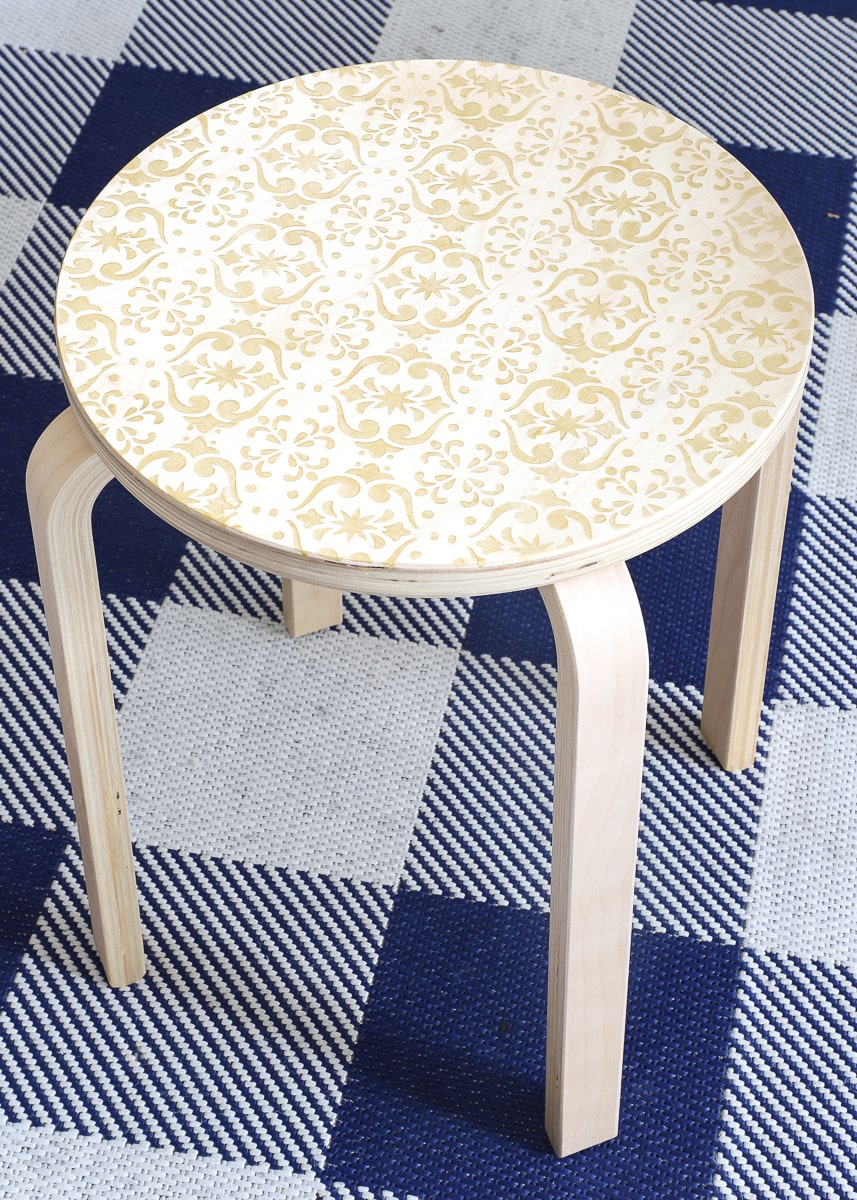 A wooden IKEA stool stenciled with a Cricut and Cricut Stencil Vinyl