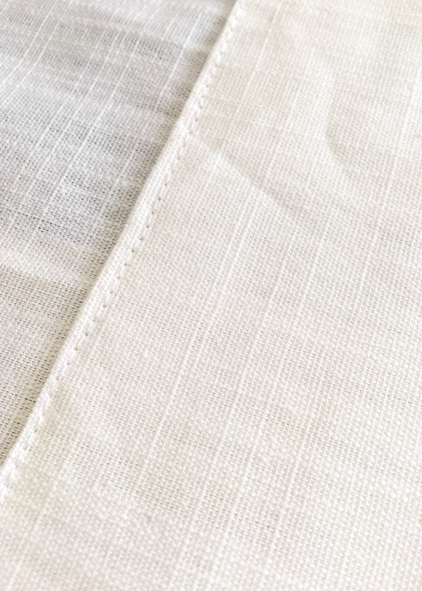 a close up image of a hem seam on a white curtain