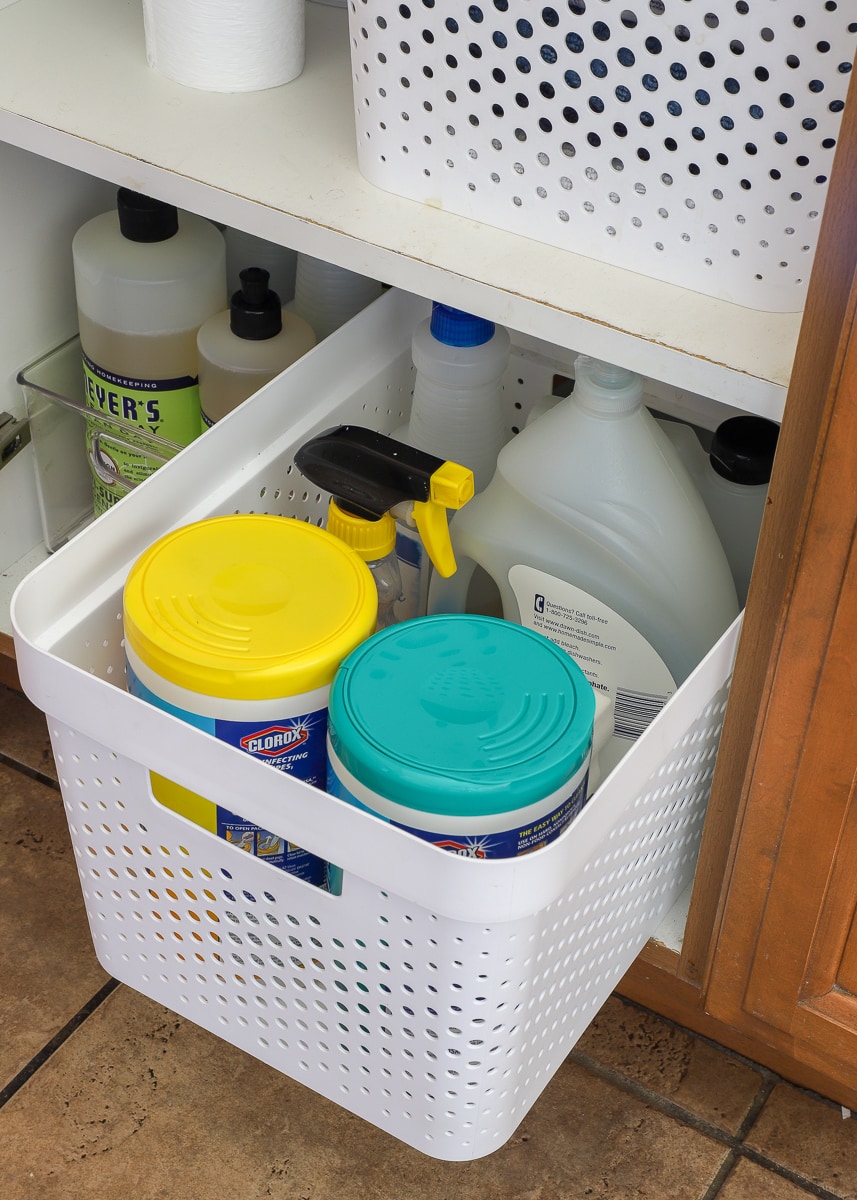 Cleaning supplies organized in a lower kitchen cabinet
