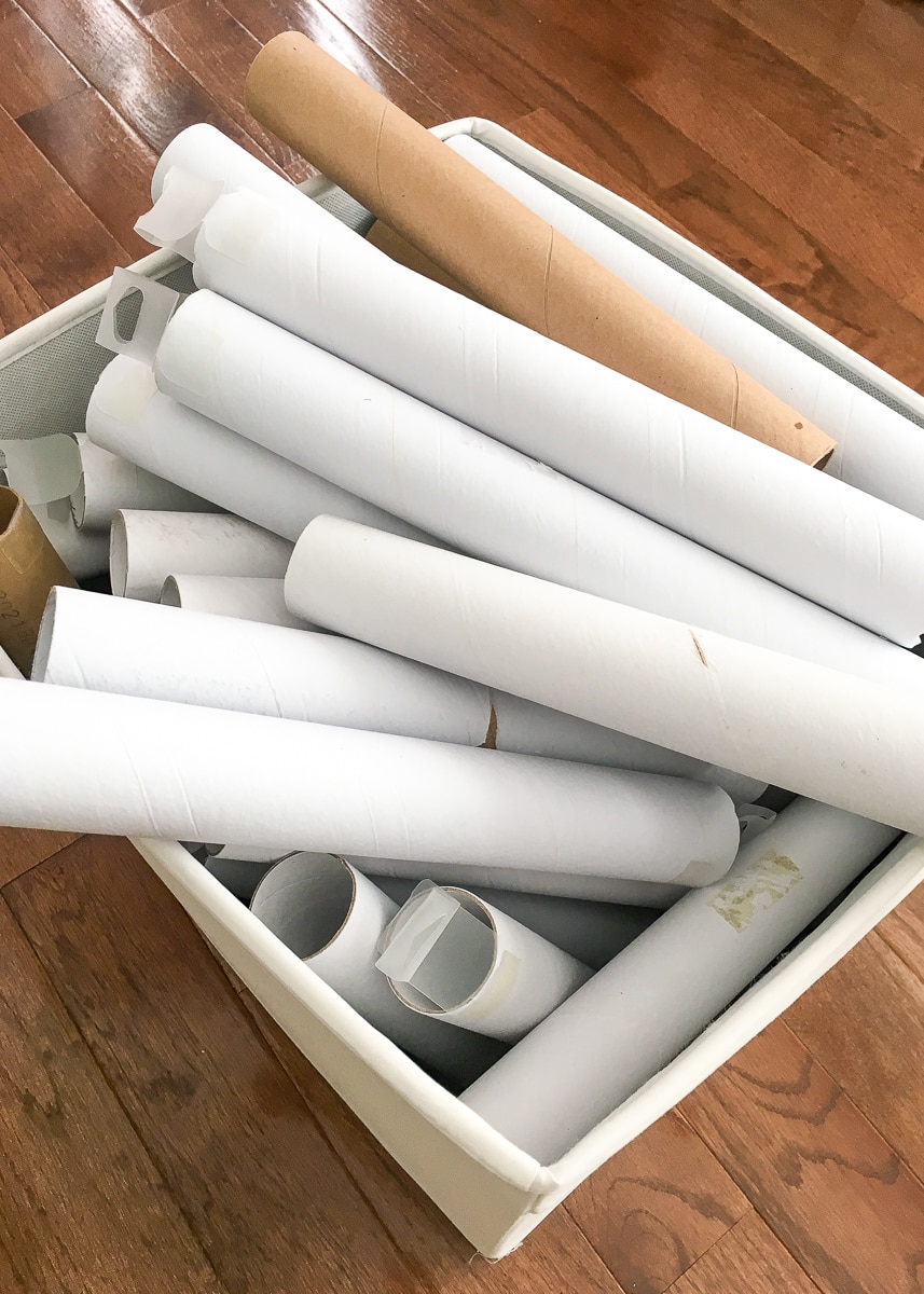 Vertical image of cardboard rolls stacked inside a white bin
