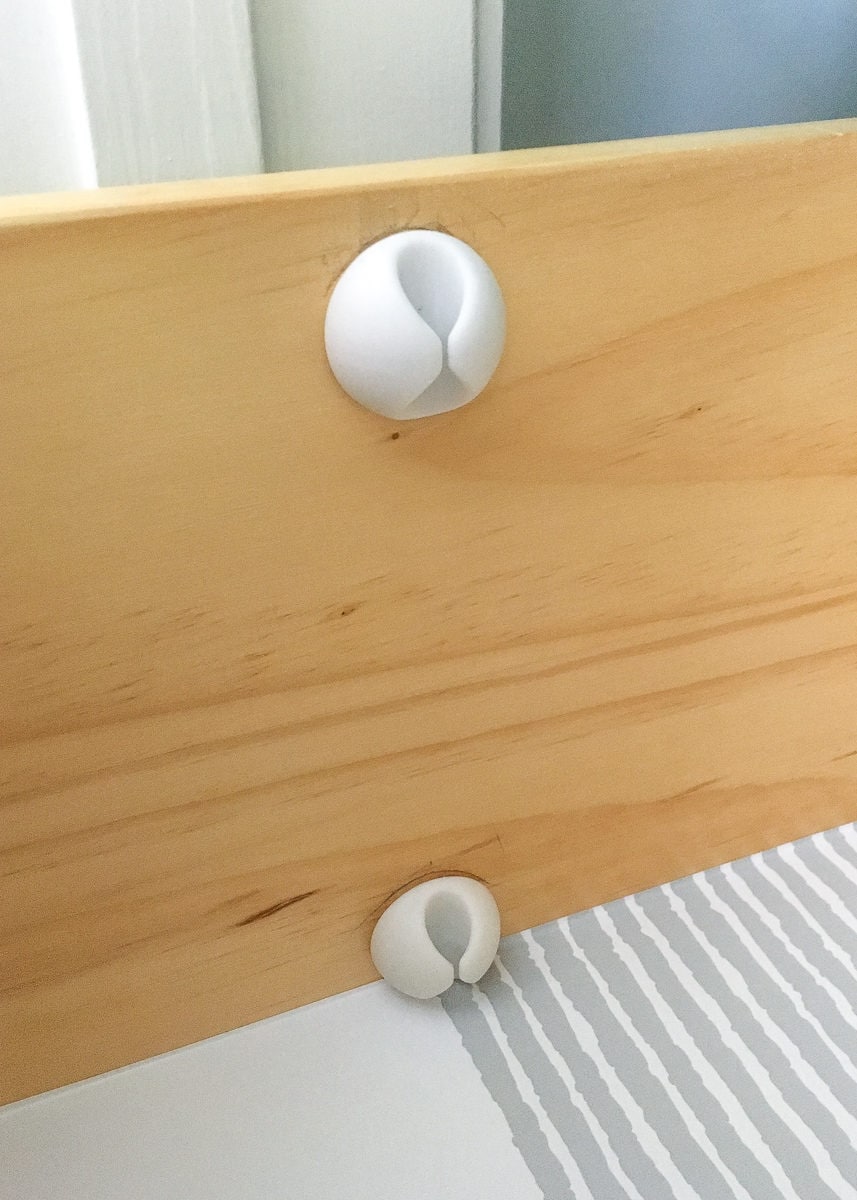 Cable clips stuck to the inside of a wooden dresser drawer