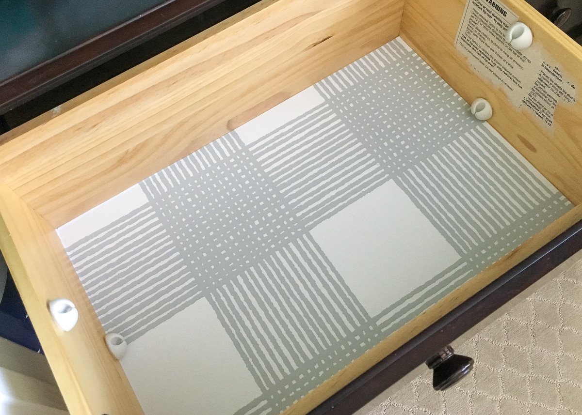 A drawer lined with contact paper and adhesive cable clips are positioned on the sides