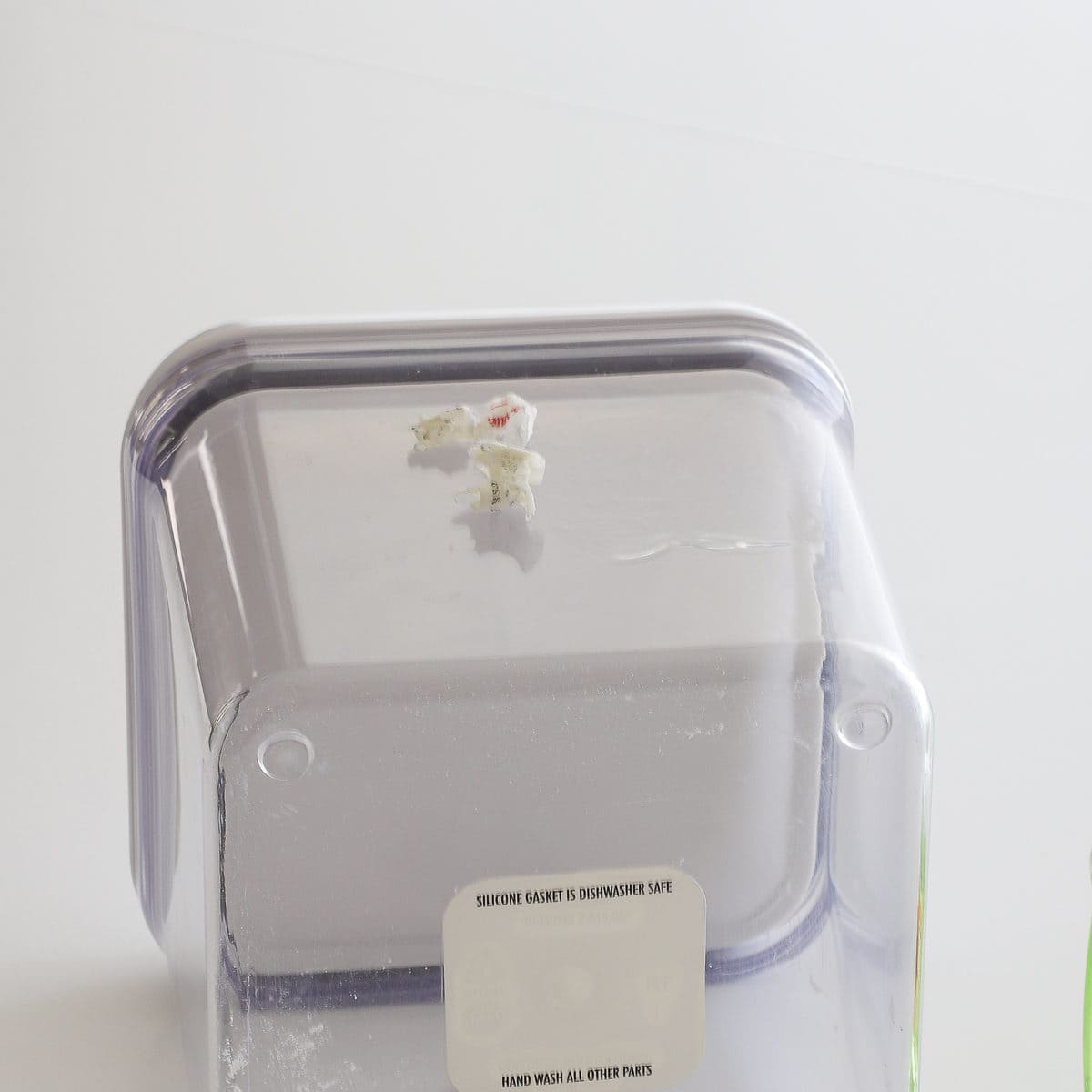 A clear container with paper sticker peeled up removed