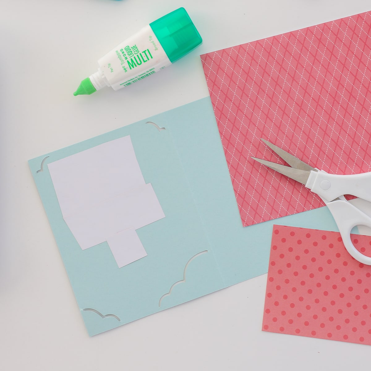 Various patterned papers are trimmed with scissors