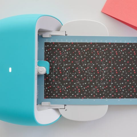 Adhesive-backed paper loaded on the Cricut Joy Mat is fed into the Cricut Joy machine