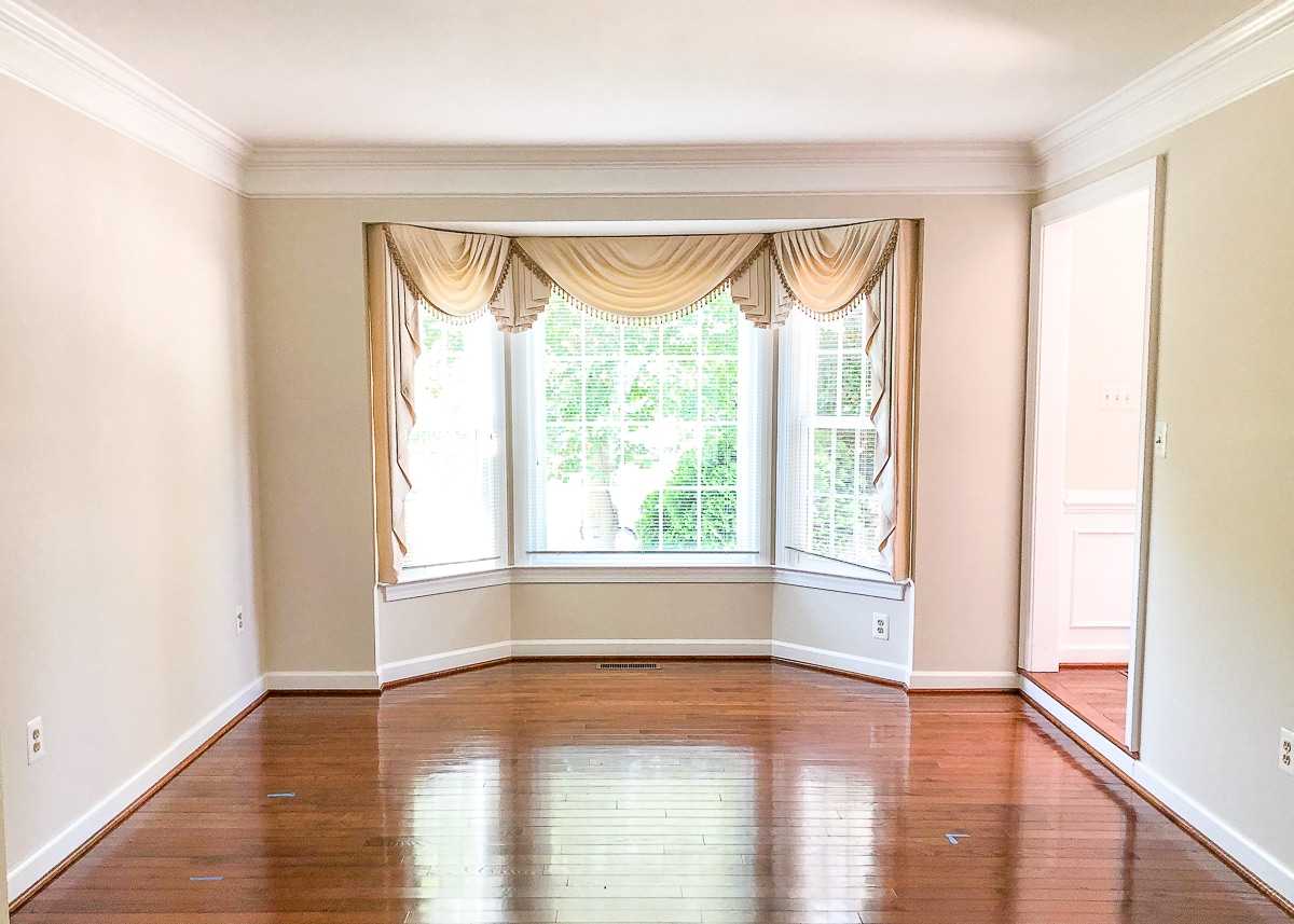 empty living room with dated bay curtains