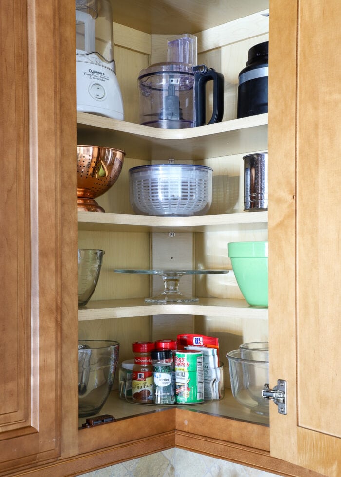 Round items placed in an L-shaped corner kitchen cabinet