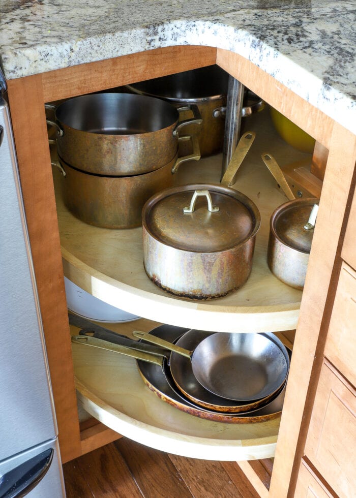pots and pans stored on a turntable within a lower kitchen cabinet
