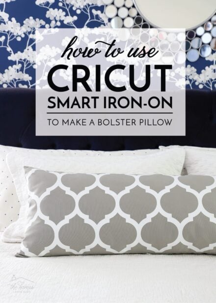 Grey custom bolster pillow made with Cricut Smart Iron-on on a white bed against a blue wall