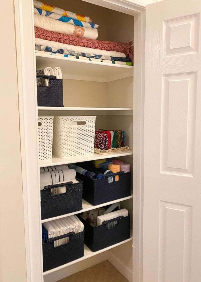 Sturdy baskets help organize this hallway linen closet.