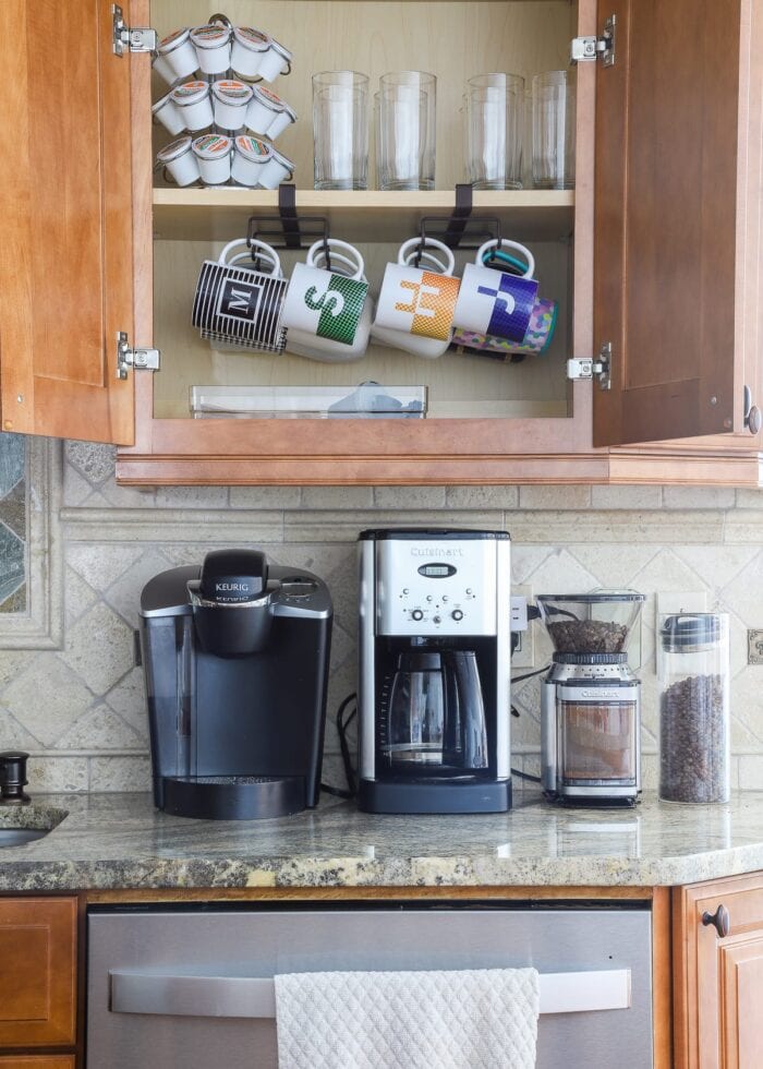 Kitchen cabinet with organized coffee mugs and supplies