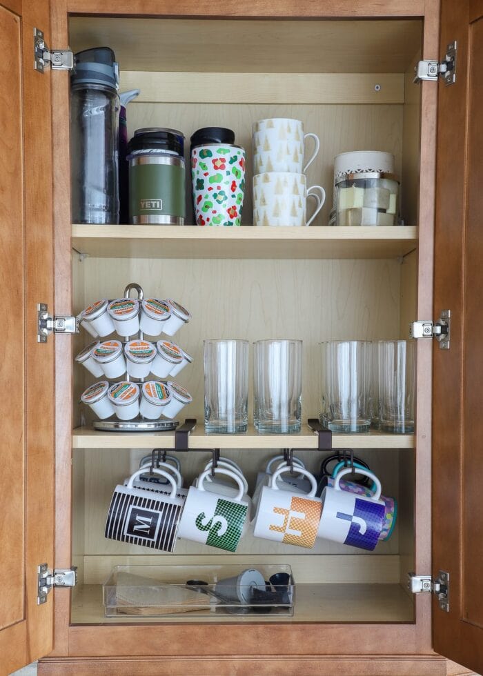 Kitchen cabinet with organized coffee mugs and supplies