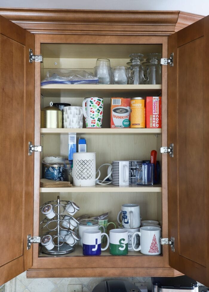 Kitchen cabinet cluttered with coffee mugs
