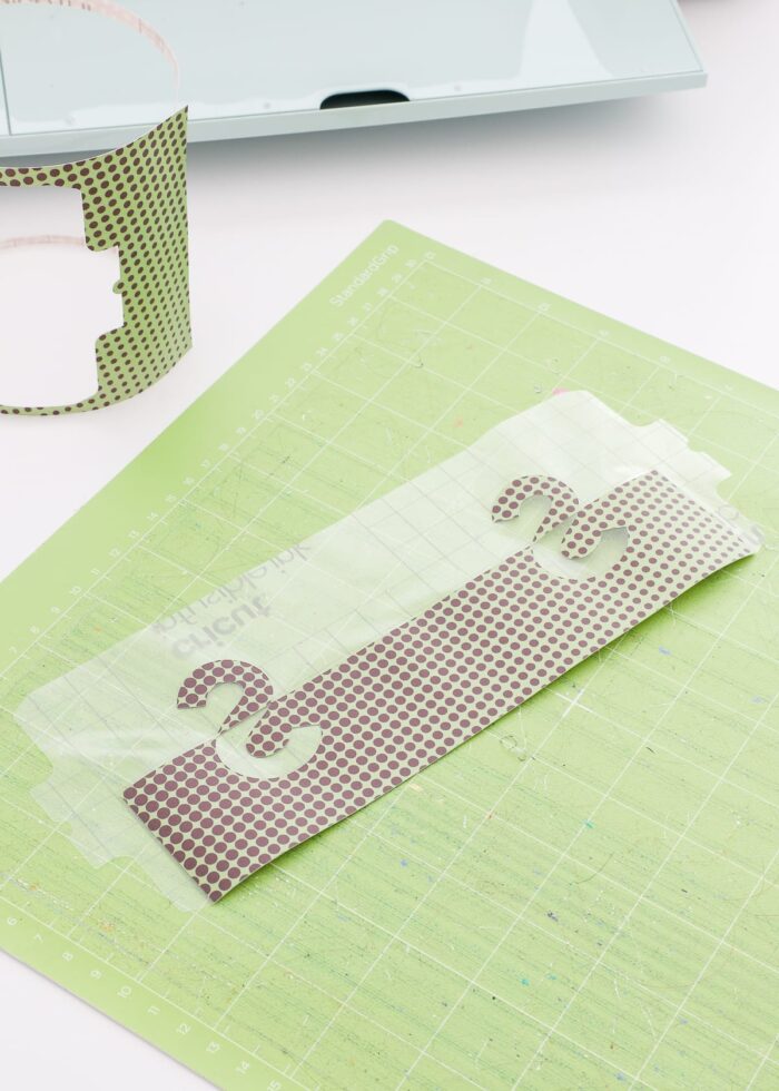 Split monogram mug design cut out of Infusible Ink Transfer Sheet on a Cricut Mat