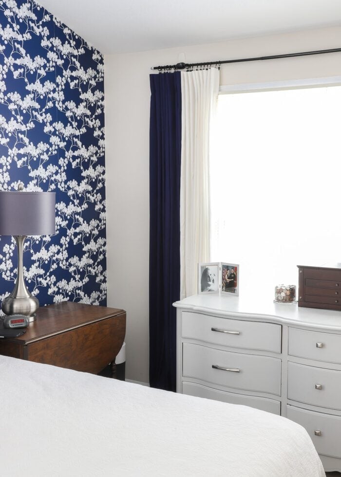 Bedroom with blue wallpaper and a curtain rod hung with Command Hooks