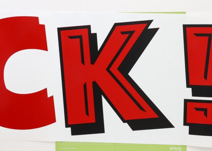 Horizontal image of red and black vinyl letters layered together