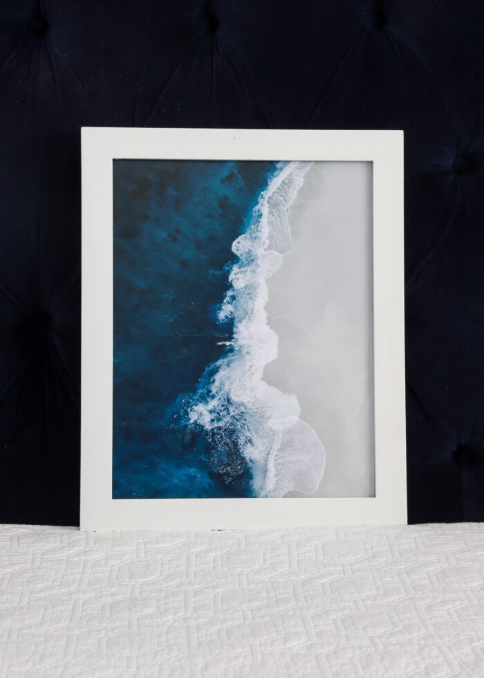 White frames with blue, white, and grey ocean artwork.
