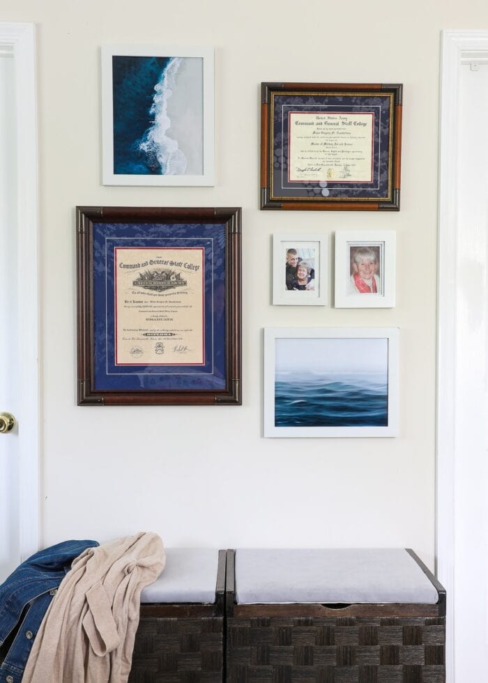Small gallery wall with white and wood frames and ocean artwork.