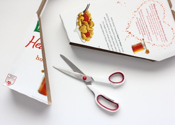 A cut cereal box shown with scissors.