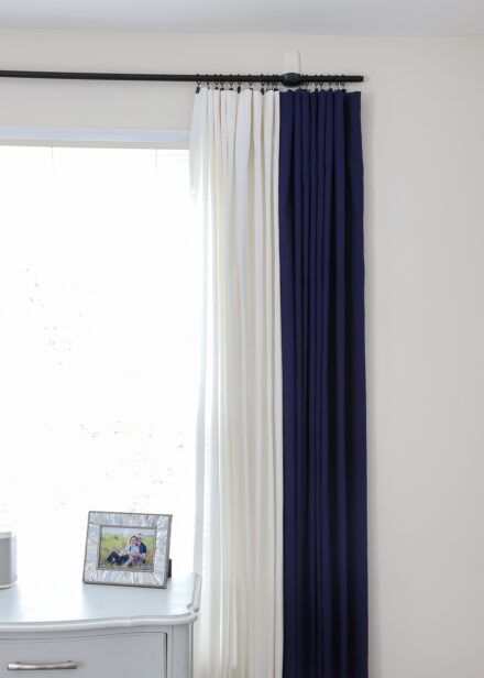 Navy and white curtains hung on a black curtain rod with black curtain rings