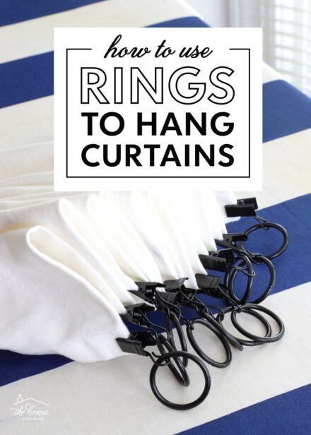 Black curtain rings on the top of a white curtain panel