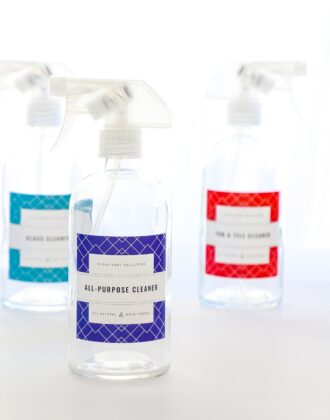 Glass cleaning spray bottles with red, blue, and turquoise printable cleaning labels.