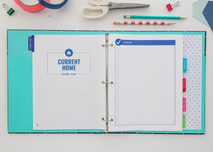 Printable Moving Binder opened on a white desk with the Current Home section showing.