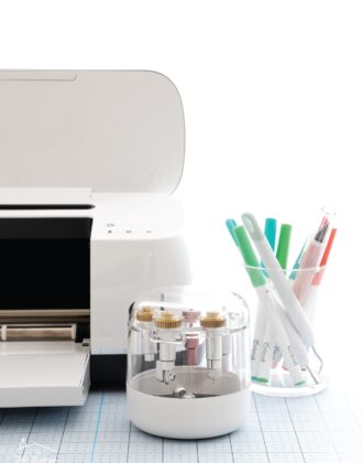 Cricut Maker shown with a variety of blades, tools, and pens.